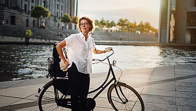 Lächelnde Frau mit Fahrrad in Berlin