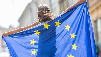Junge Frau hält eine EU-Flagge